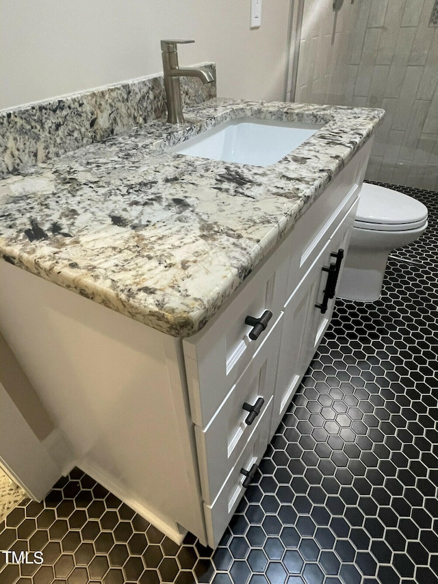 bathroom featuring vanity, toilet, and tile patterned flooring