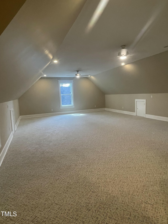 bonus room with lofted ceiling and carpet flooring