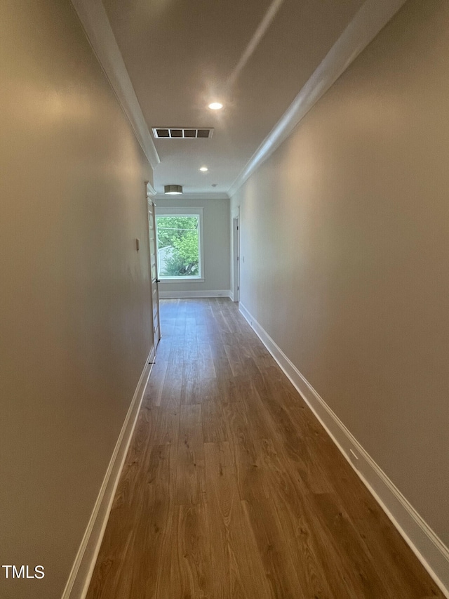 corridor featuring crown molding and hardwood / wood-style floors