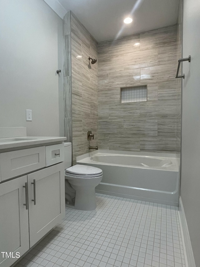 full bathroom with tile patterned flooring, toilet, tiled shower / bath combo, and vanity