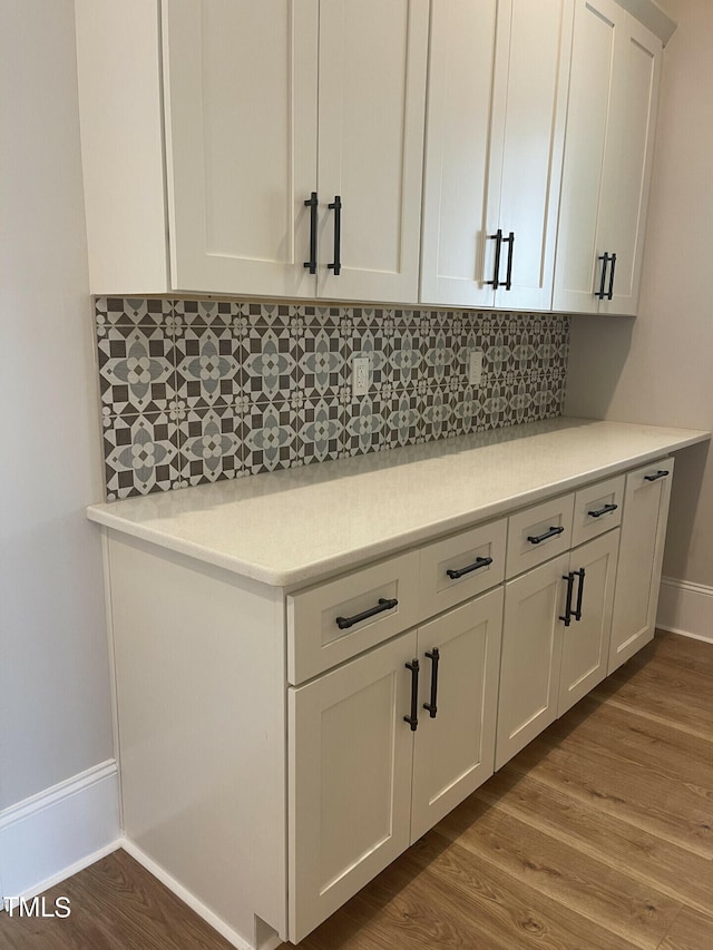 kitchen featuring white cabinetry, backsplash, and hardwood / wood-style flooring