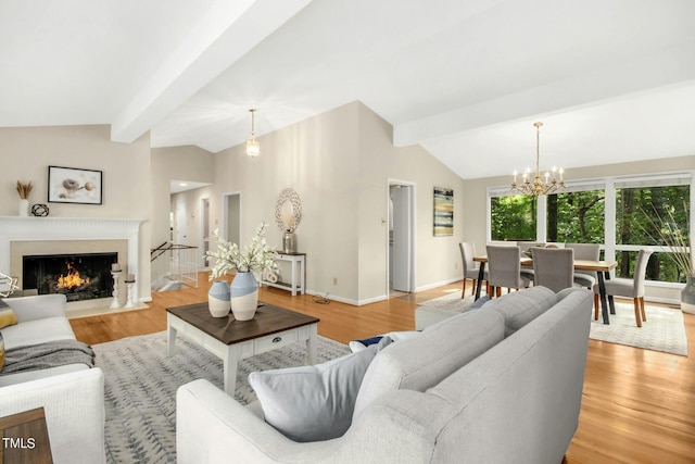 living room featuring lofted ceiling with beams, an inviting chandelier, and light hardwood / wood-style flooring