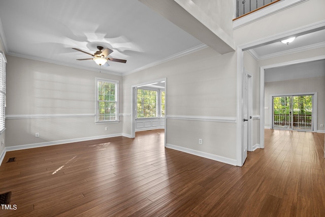 spare room featuring ornamental molding, a wealth of natural light, and dark hardwood / wood-style flooring