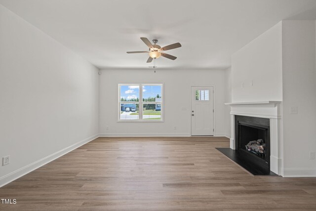 unfurnished living room featuring ceiling fan and hardwood / wood-style floors