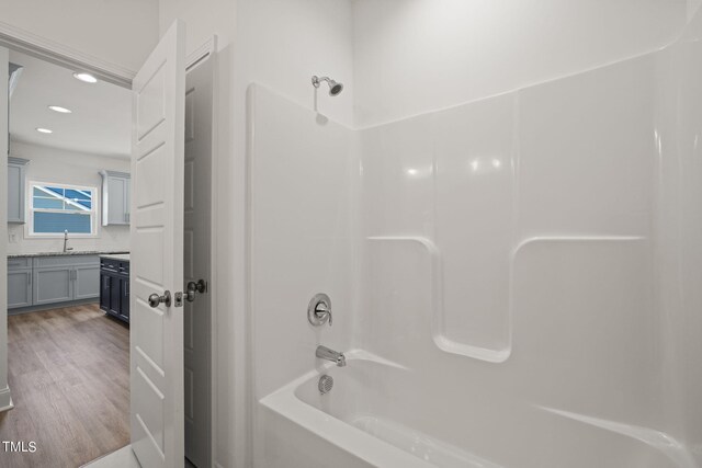 bathroom with vanity, washtub / shower combination, and hardwood / wood-style flooring