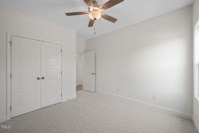 unfurnished bedroom featuring a closet, ceiling fan, and light colored carpet