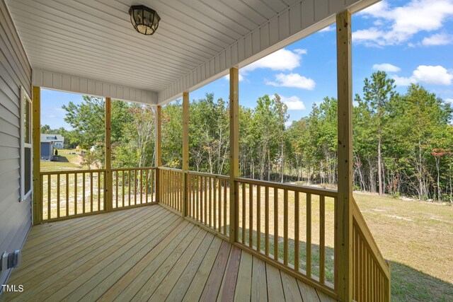 wooden terrace featuring a lawn