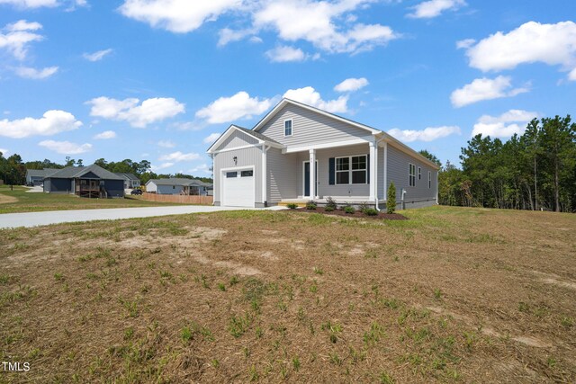 view of front of house with a front lawn, a garage, and a porch