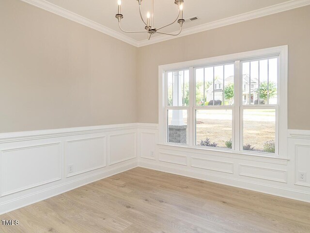 unfurnished room with light wood-type flooring, crown molding, and a wealth of natural light