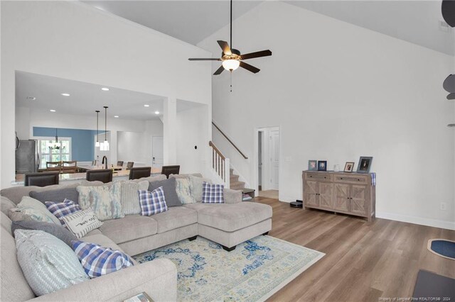 living room with high vaulted ceiling, hardwood / wood-style flooring, and ceiling fan