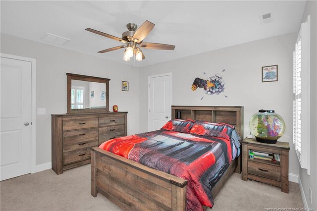 bedroom with light carpet, multiple windows, and ceiling fan