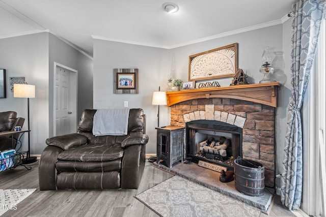 living room with a fireplace, ornamental molding, and hardwood / wood-style floors