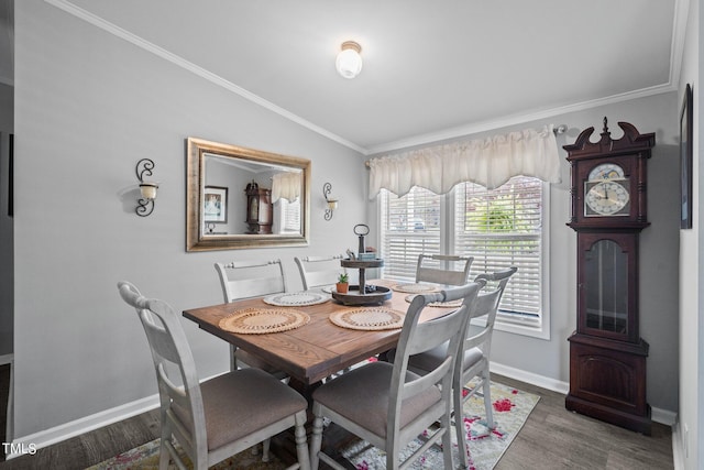 dining space featuring crown molding, dark wood-type flooring, and vaulted ceiling