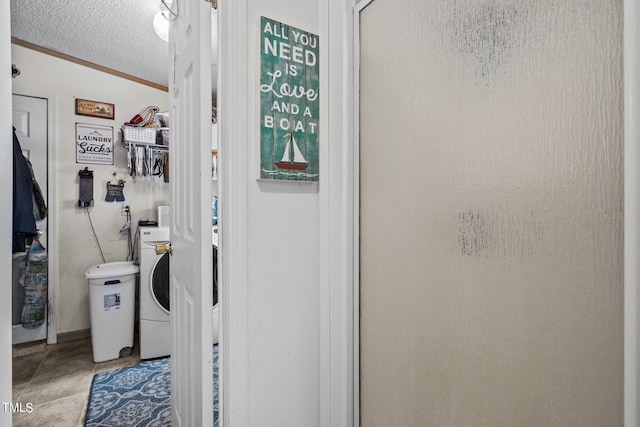 bathroom featuring washer / dryer, crown molding, and a textured ceiling