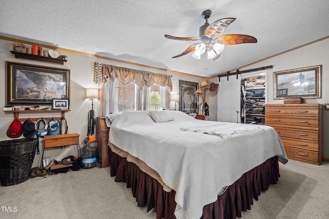 bedroom featuring ornamental molding, lofted ceiling, a barn door, ceiling fan, and light colored carpet