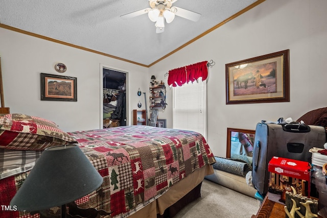 bedroom featuring vaulted ceiling, a walk in closet, a closet, ceiling fan, and ornamental molding