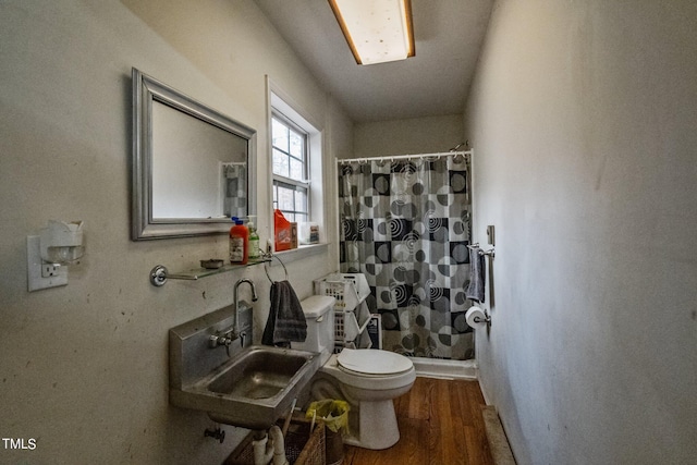 bathroom featuring toilet, a shower with shower curtain, hardwood / wood-style floors, and sink