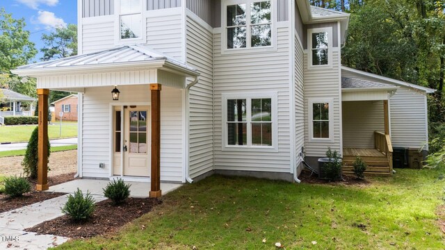 rear view of property with a lawn and covered porch