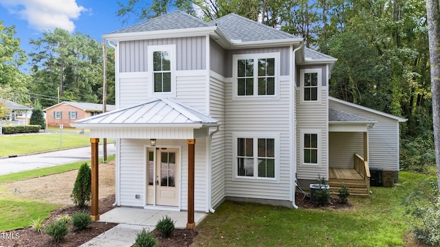 view of front of home featuring central AC unit, a porch, and a front yard