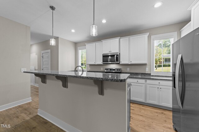 kitchen featuring a wealth of natural light, white cabinets, and appliances with stainless steel finishes