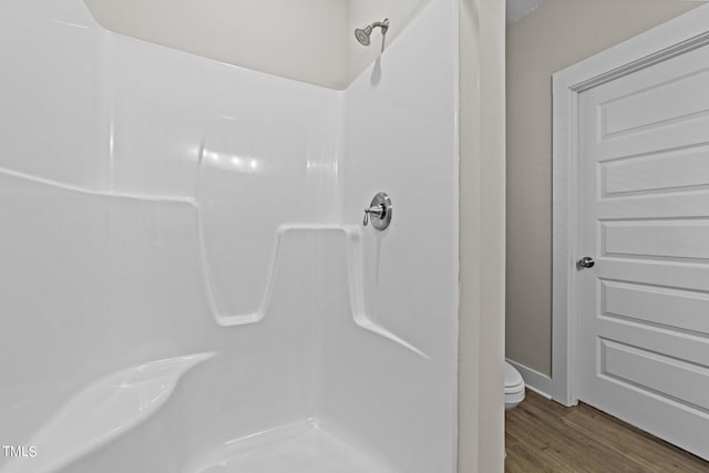 bathroom featuring hardwood / wood-style flooring, toilet, and walk in shower