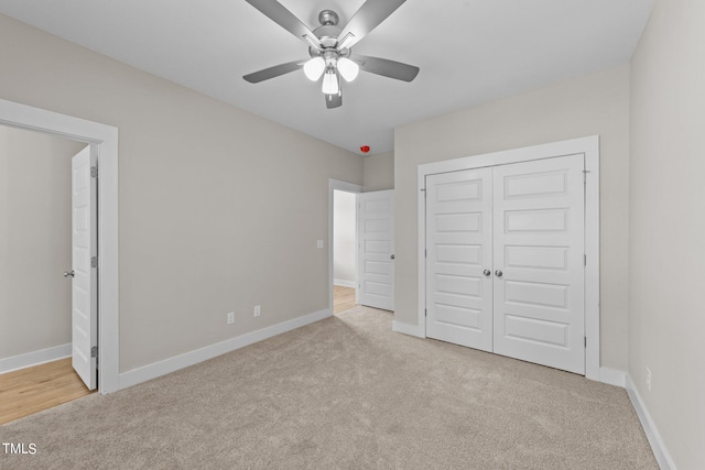 unfurnished bedroom featuring a closet, light colored carpet, and ceiling fan