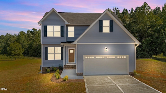 view of front of house with a yard and a garage