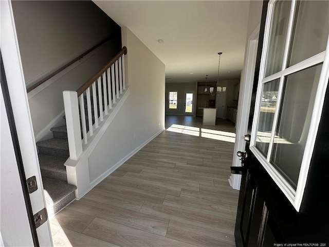 interior space with a notable chandelier and light hardwood / wood-style flooring