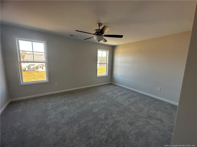 unfurnished room featuring dark colored carpet and ceiling fan