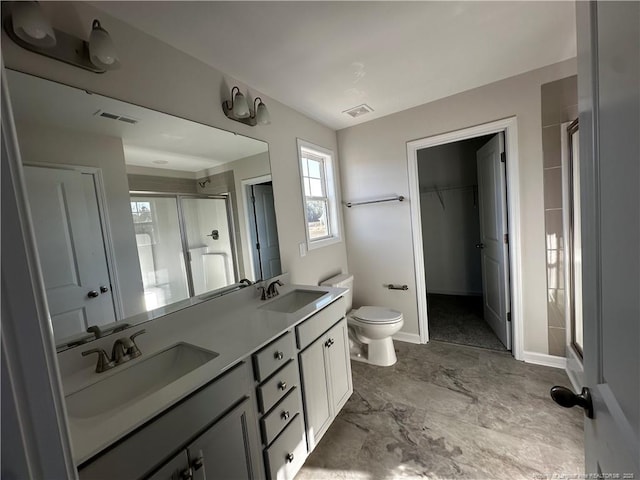 bathroom featuring vanity, toilet, and walk in shower