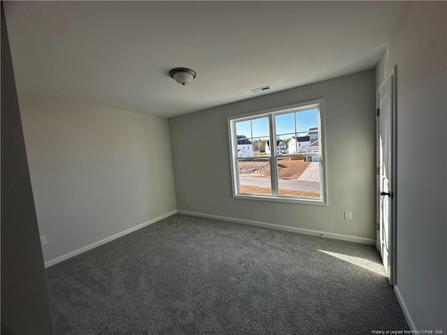 unfurnished room featuring dark colored carpet