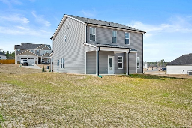 rear view of property featuring a lawn