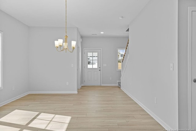 foyer entrance featuring baseboards, an inviting chandelier, stairs, light wood-style floors, and recessed lighting