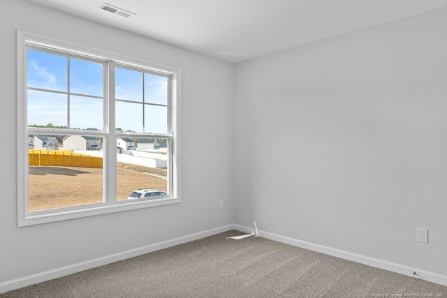 carpeted empty room featuring visible vents and baseboards