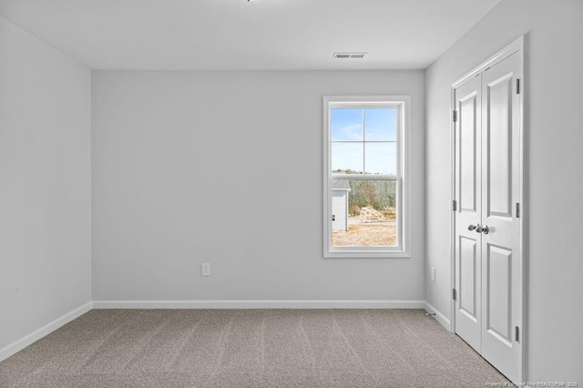 carpeted empty room with baseboards and visible vents