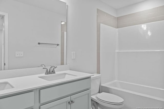 full bathroom featuring toilet, double vanity, bathtub / shower combination, and a sink