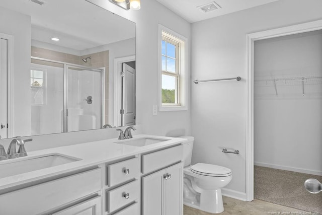 full bath featuring toilet, a shower stall, visible vents, and a sink