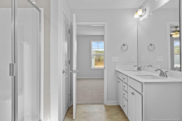 bathroom featuring double vanity, a stall shower, baseboards, and a sink