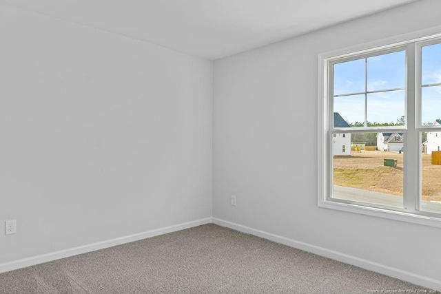 unfurnished room with carpet floors and baseboards