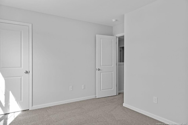 unfurnished bedroom with carpet floors and baseboards