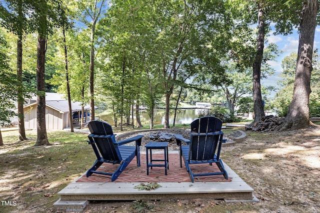 exterior space with a fire pit and a deck with water view