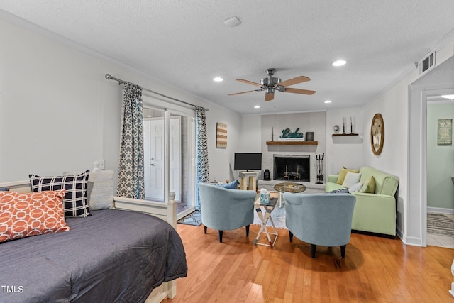 bedroom featuring a textured ceiling, light hardwood / wood-style flooring, and ceiling fan