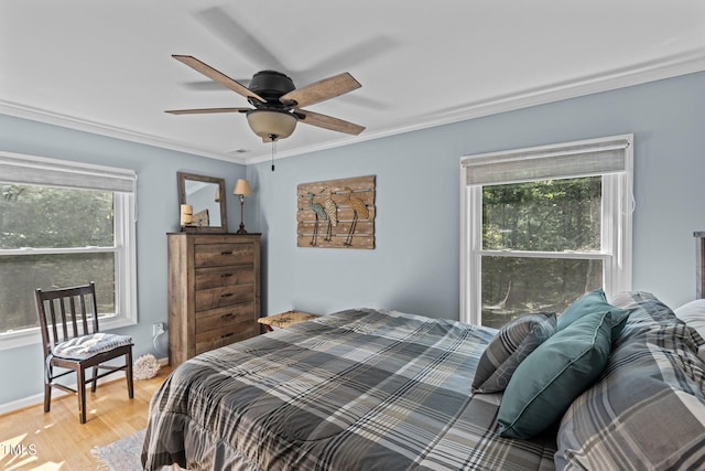 bedroom with crown molding, light hardwood / wood-style flooring, and ceiling fan