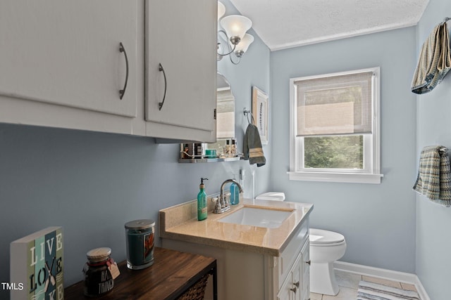 bathroom featuring a textured ceiling, vanity, toilet, and tile patterned flooring