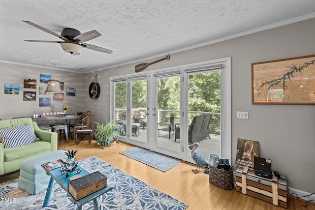 living room with ornamental molding, a textured ceiling, ceiling fan, french doors, and hardwood / wood-style flooring