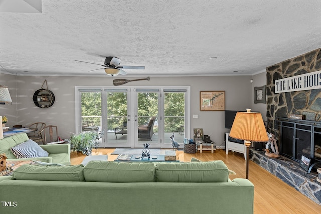 living room with a fireplace, a textured ceiling, hardwood / wood-style flooring, and ceiling fan