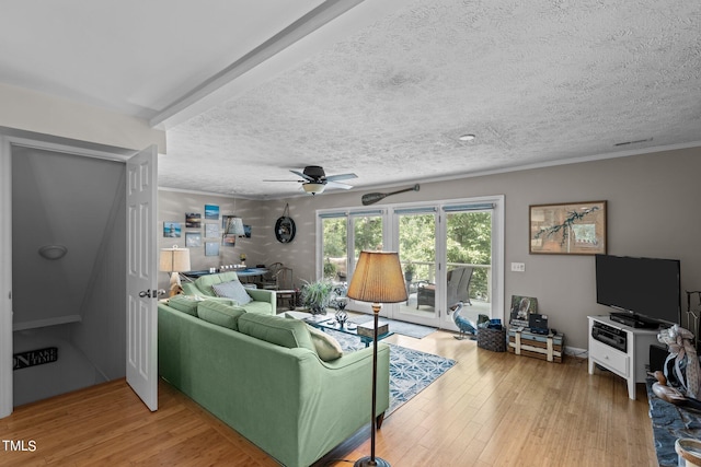 living room featuring a textured ceiling, hardwood / wood-style flooring, and ceiling fan