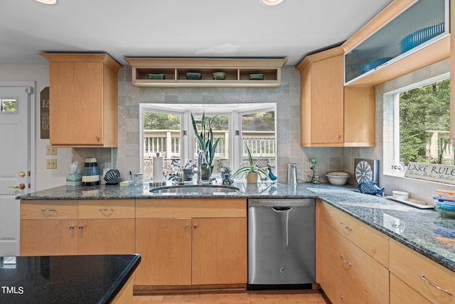 kitchen featuring dishwasher, dark stone counters, light brown cabinetry, and backsplash