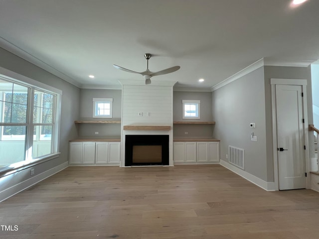 unfurnished living room with a large fireplace, plenty of natural light, and light hardwood / wood-style flooring