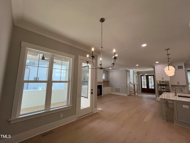 kitchen with sink, hanging light fixtures, light hardwood / wood-style flooring, double oven, and white cabinetry